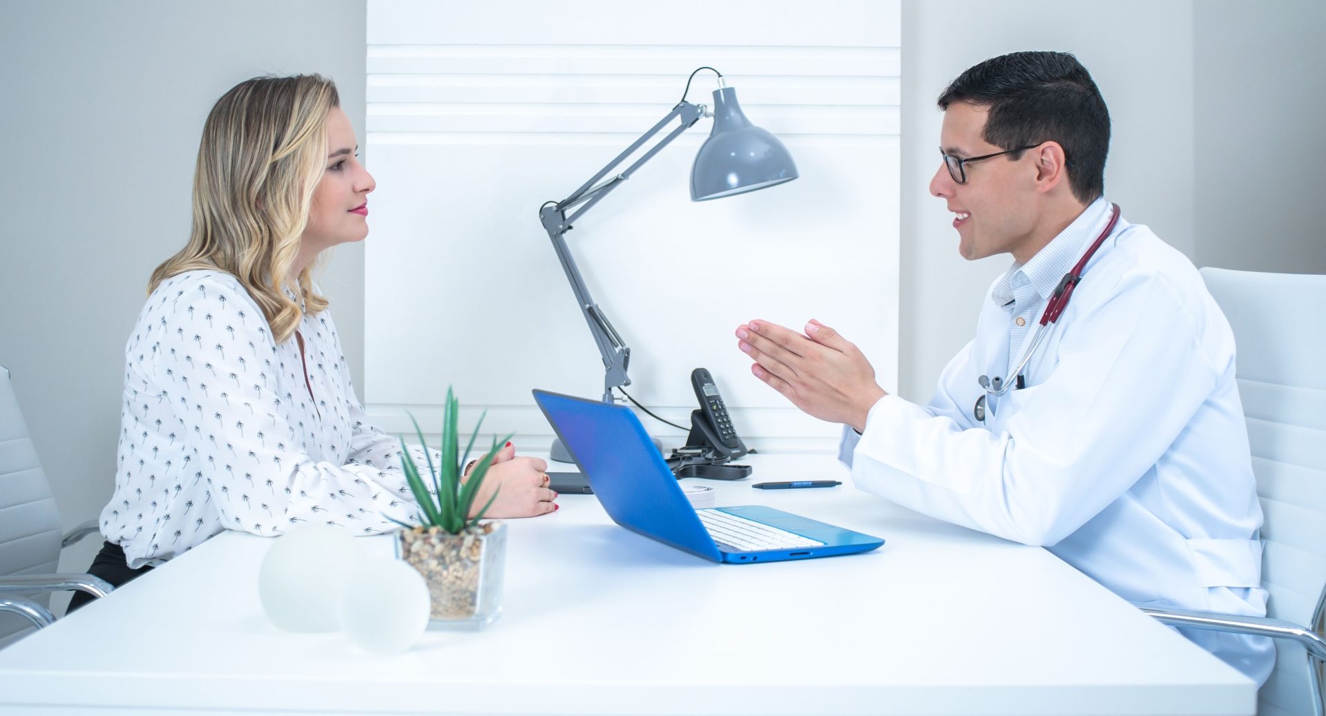 A doctor conducts a patient consultation in a bright, modern medical office.